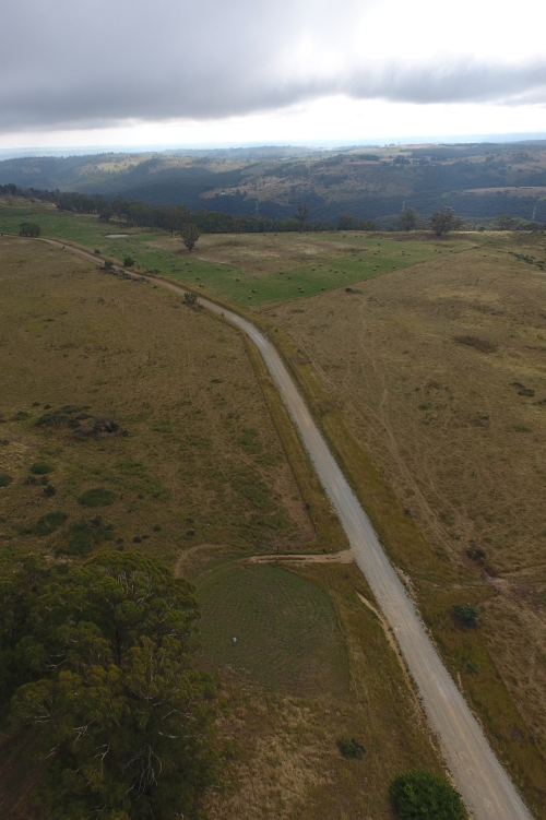 drone footage of steep farmland with a dirt road